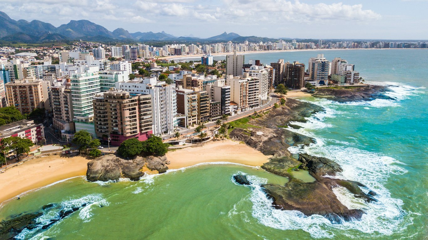 Paisagem urbana no Espírito Santo com morros e vegetação de Mata Atlântica, fim de tarde