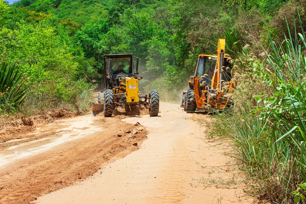 Máquinas pesadas trabalhando em estrada rural no Brasil