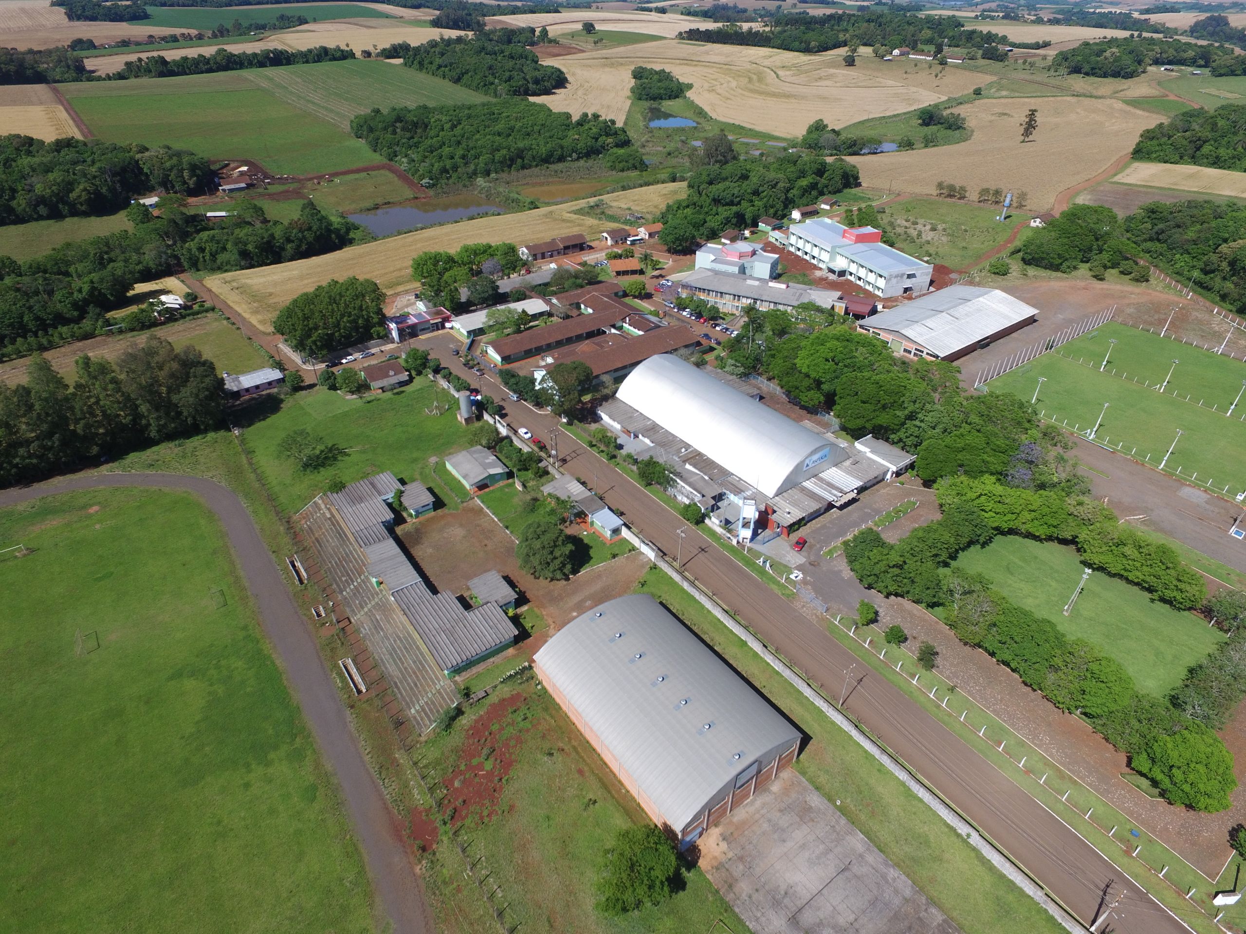 Vista aérea de cidade do interior gaúcho, com quarteirões, edificações e áreas verdes sob céu claro