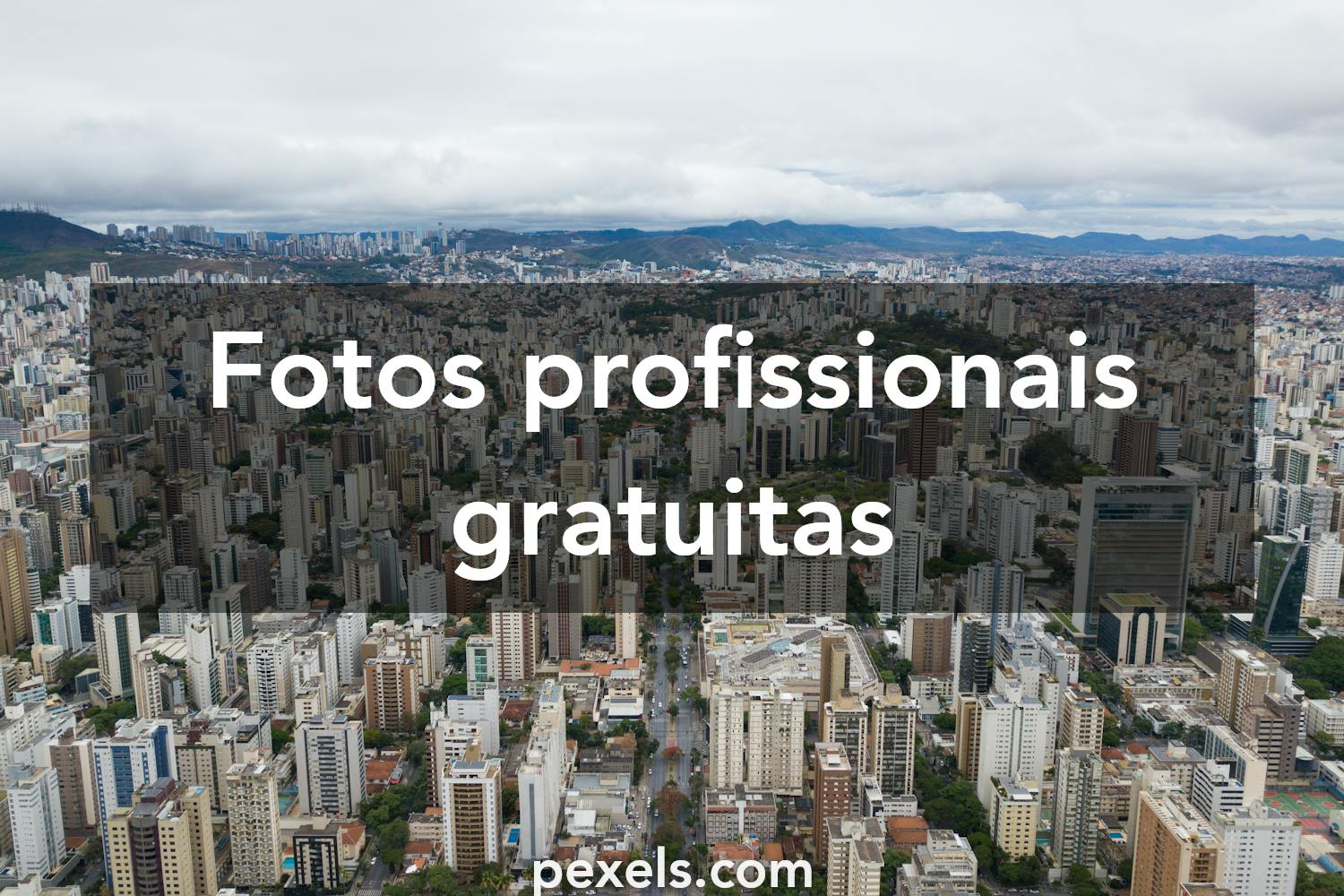 Vista de Belo Horizonte ao entardecer, com prédios e montanhas ao fundo