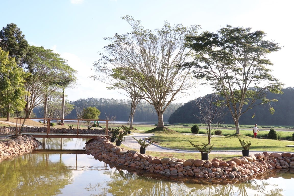 Parque Oriental de Ribeirão Pires, com lago, passarela de madeira e áreas ajardinadas ao fundo.