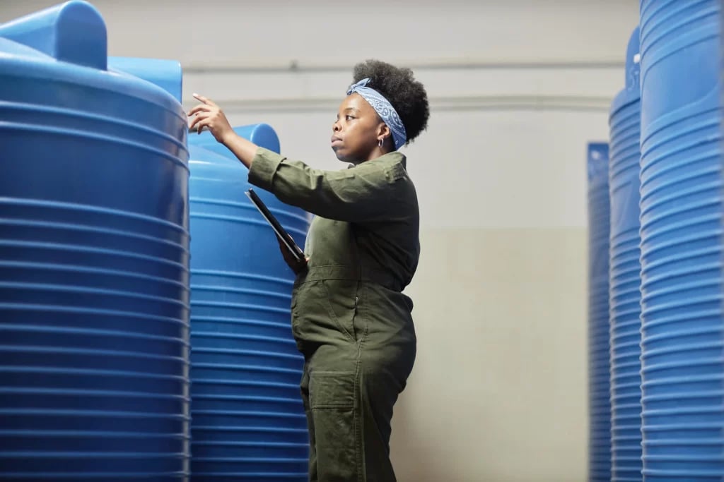 Profissional técnico em inspeção, com EPI e tablet em ambiente urbano/industrial