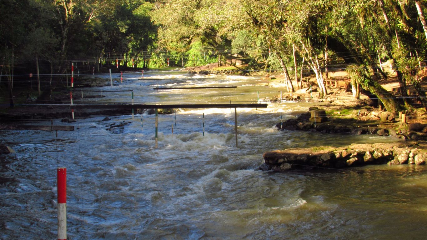 Rio Paranhana no Vale do Paranhana, vegetação e morros em dia ensolarado