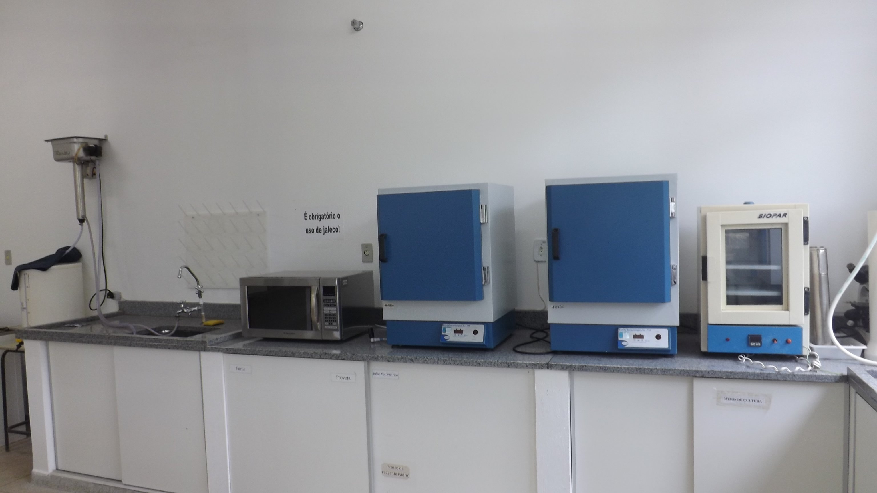 Ambiente de laboratório de microbiologia com placas de Petri e equipamentos de bancada, sem pessoas identificáveis