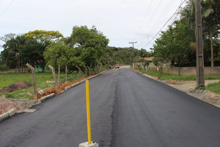 Estrada asfaltada no interior com veículo em movimento e céu aberto