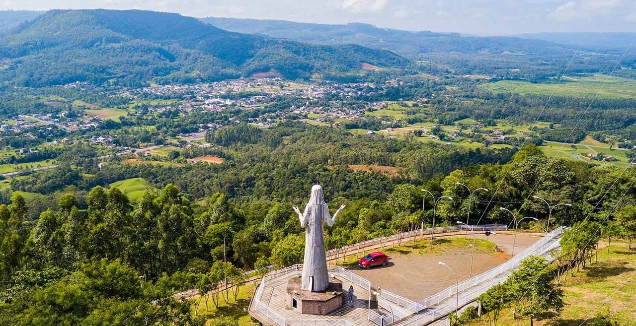 Paisagem do Oeste catarinense, com estrada rural e áreas cultivadas sob céu limpo