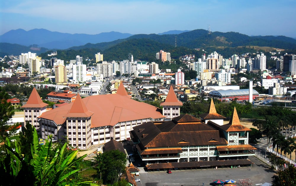 Vista aérea de uma cidade de pequeno porte no Oeste catarinense, com área urbana arborizada e céu azul