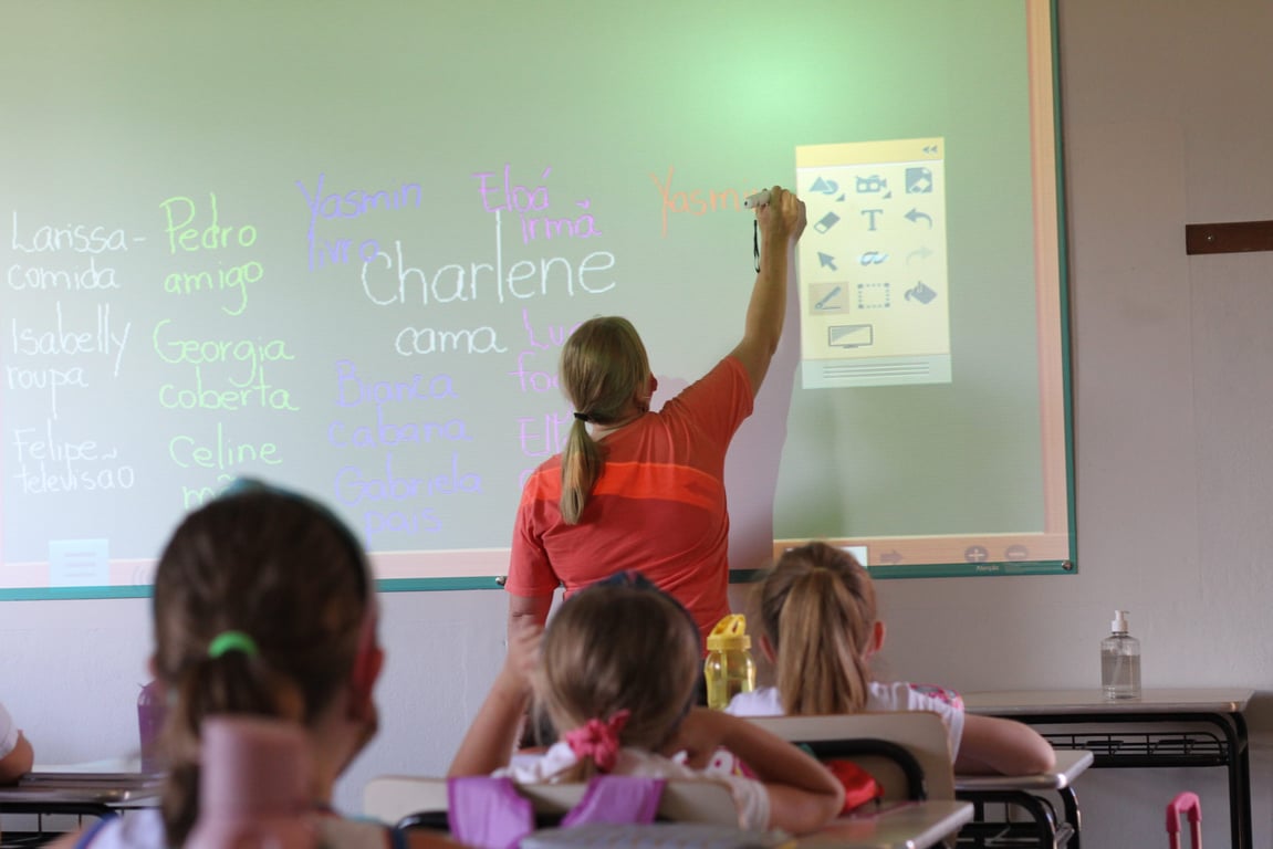 Sala de aula de escola pública com professor e alunos em ambiente acolhedor