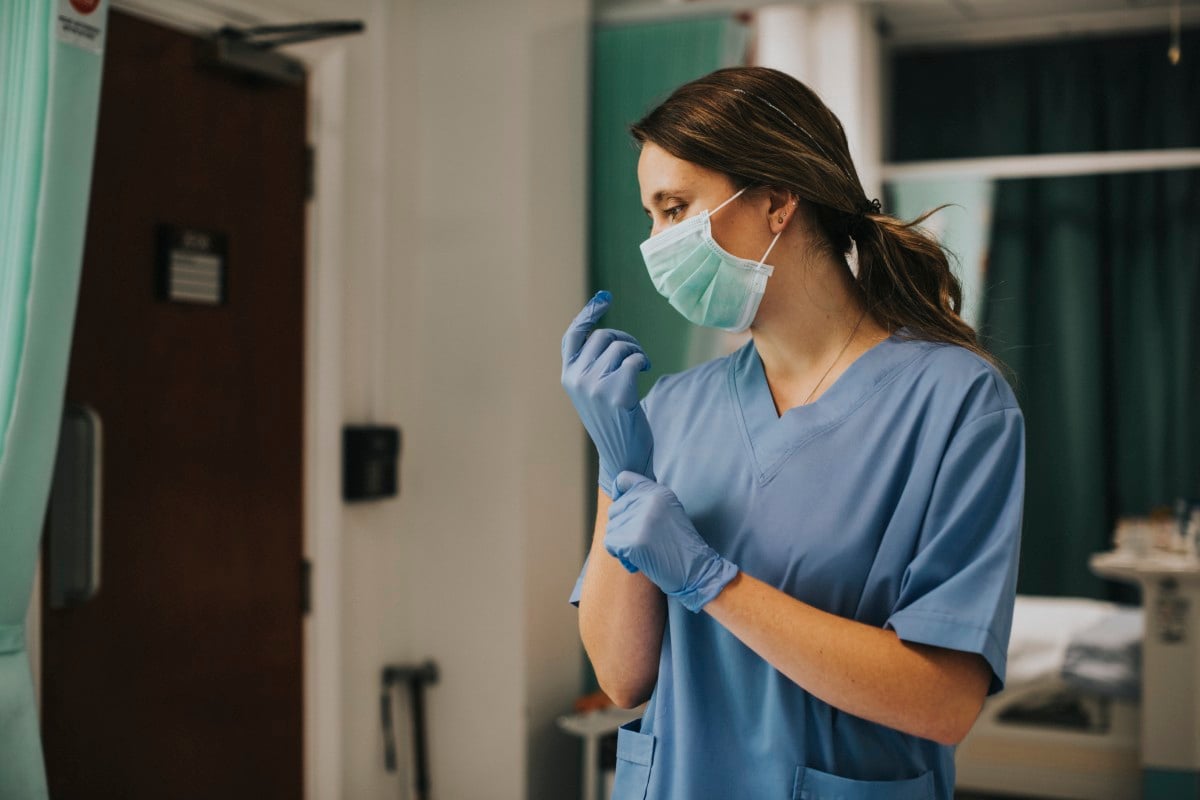 Profissional de enfermagem com EPIs em unidade de saúde