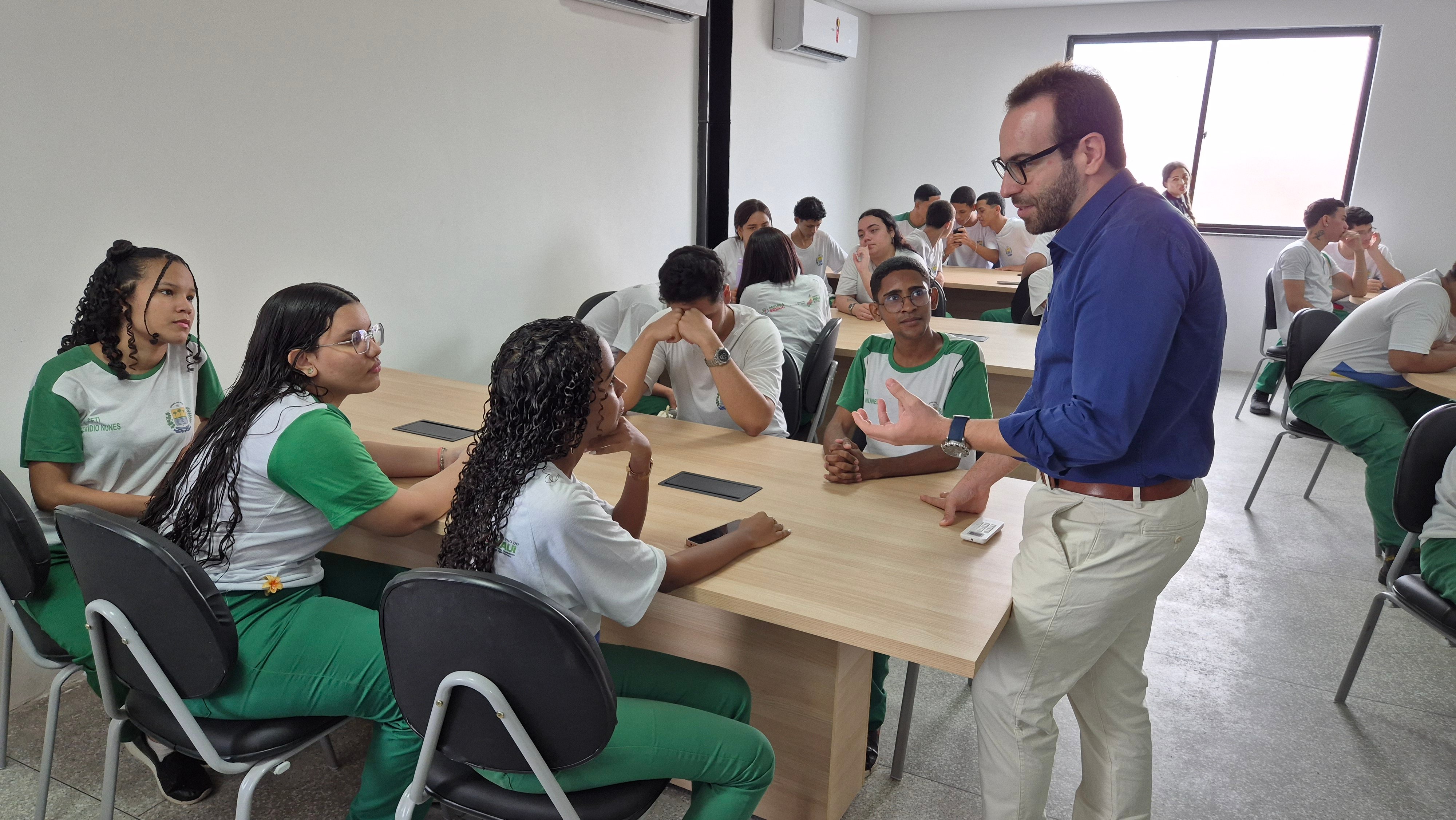 Sala de aula moderna com estudantes e professor em atividade, em ambiente institucional de ensino técnico