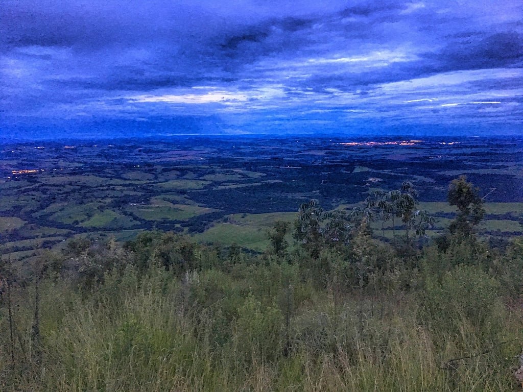 Vista aérea de Cássia dos Coqueiros, com morros e área verde ao fundo
