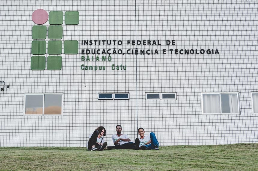 Fachada do IF Baiano em Catu, com estudantes no gramado em frente ao prédio