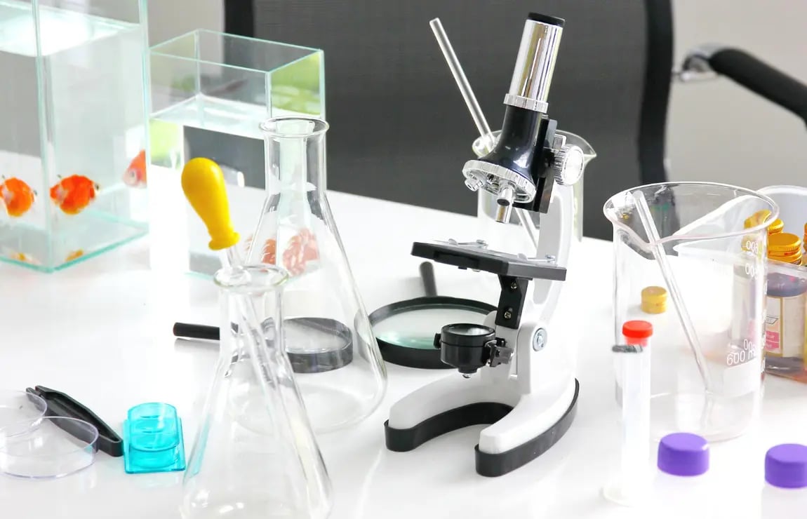 Ambiente de laboratório clínico moderno, com bancada, microscópio e vidrarias