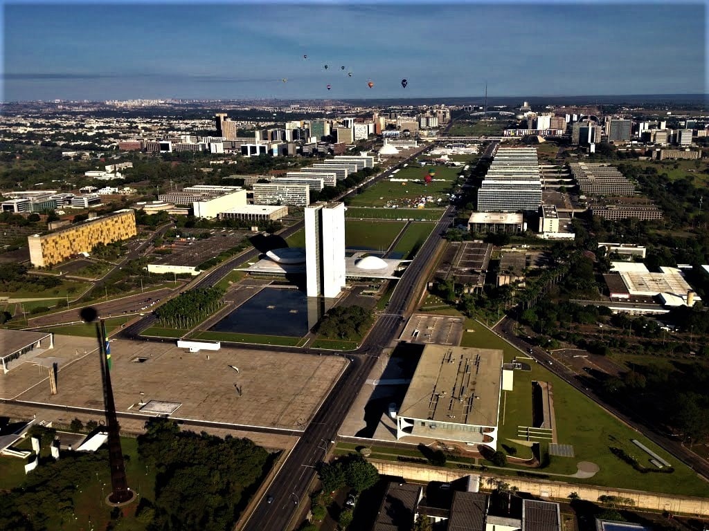 Prédio público municipal com bandeiras hasteadas em dia claro
