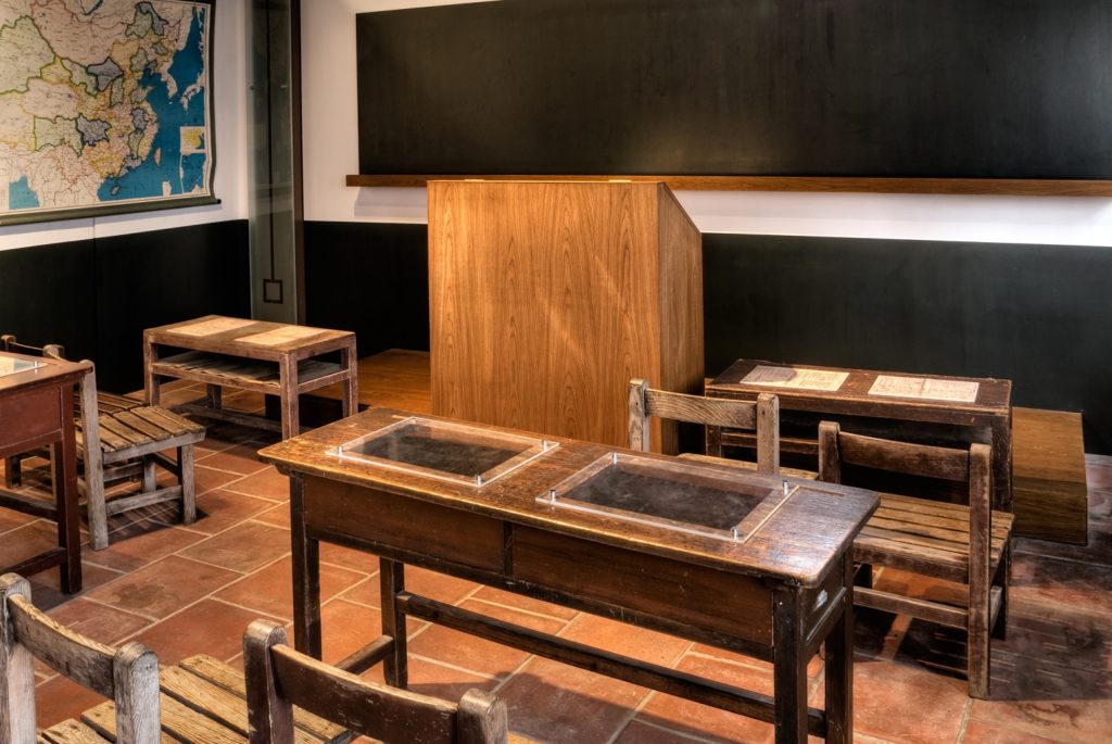 Sala de aula de ensino fundamental, com carteiras e quadro negro