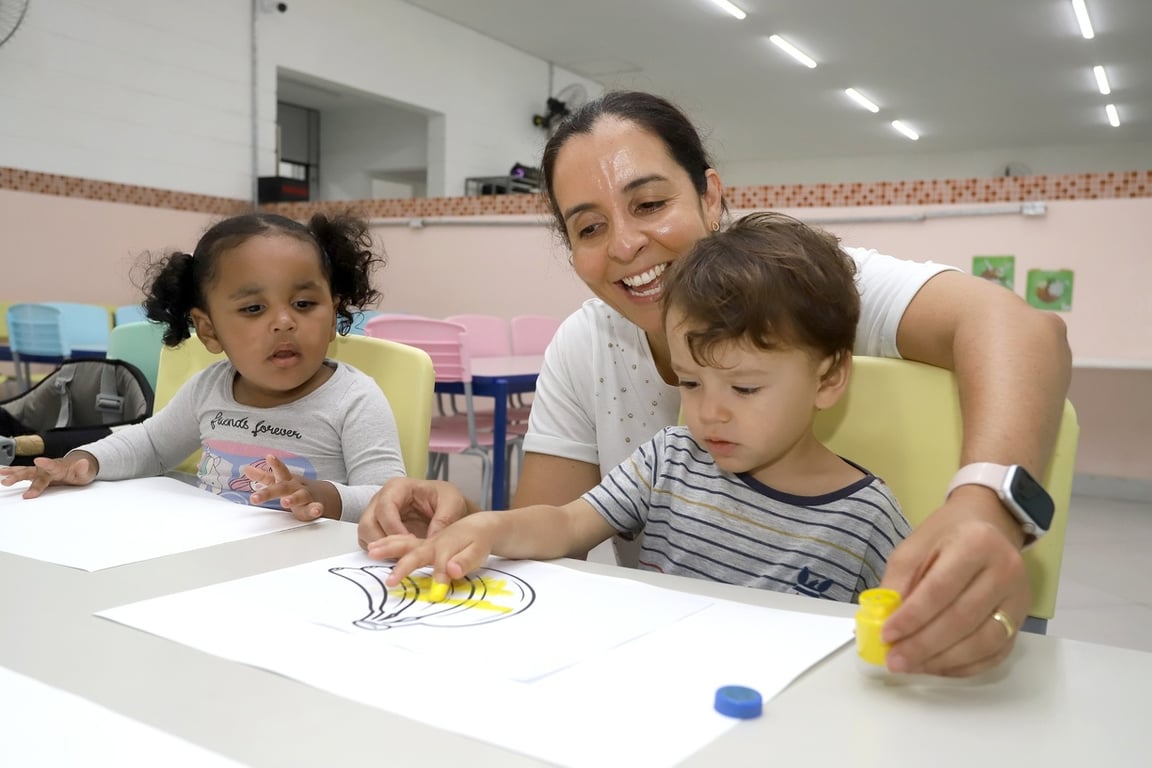 Sala de aula da educação infantil, com professora e crianças em atividade