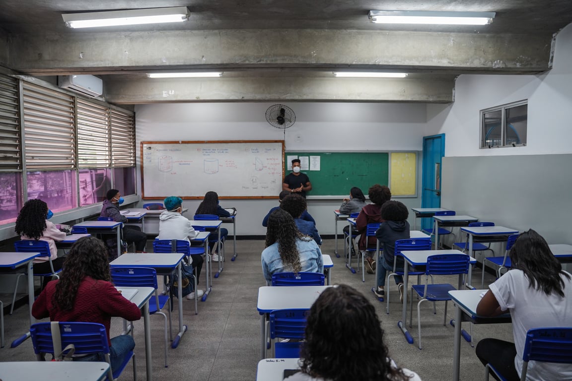 Sala de aula em escola pública no Brasil, com alunos e professor; ambiente iluminado por luz natural, em referência aos cargos da Educação