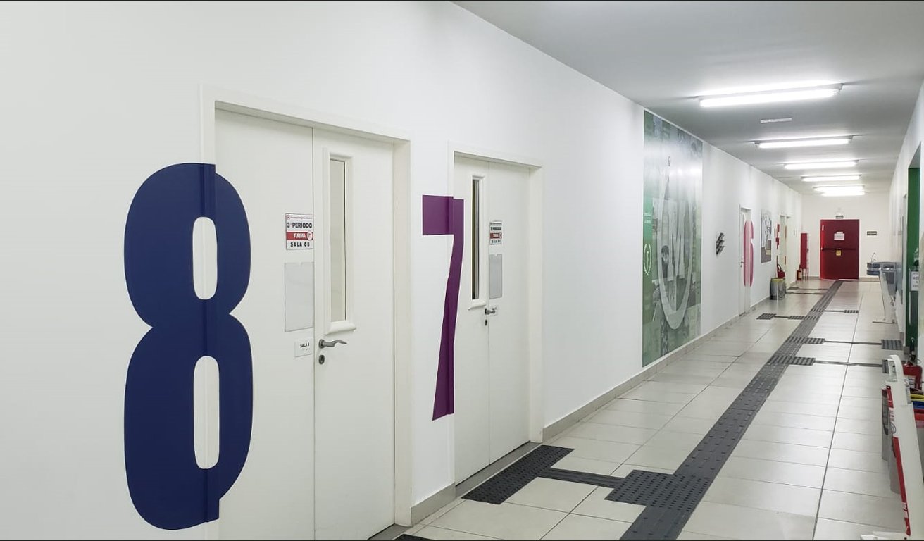 Corredor escolar com portas de salas de aula numeradas