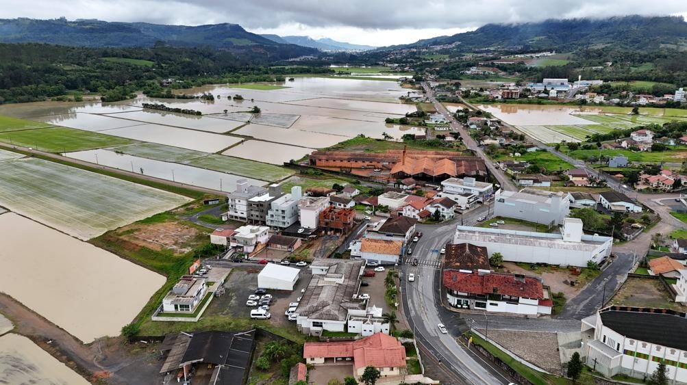Vista aérea de Agronômica SC, no Alto Vale do Itajaí, com áreas urbanas, campos e morros ao fundo