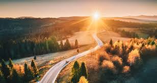 Estrada rural asfaltada no interior do Rio Grande do Sul, ladeada por vegetação e morros