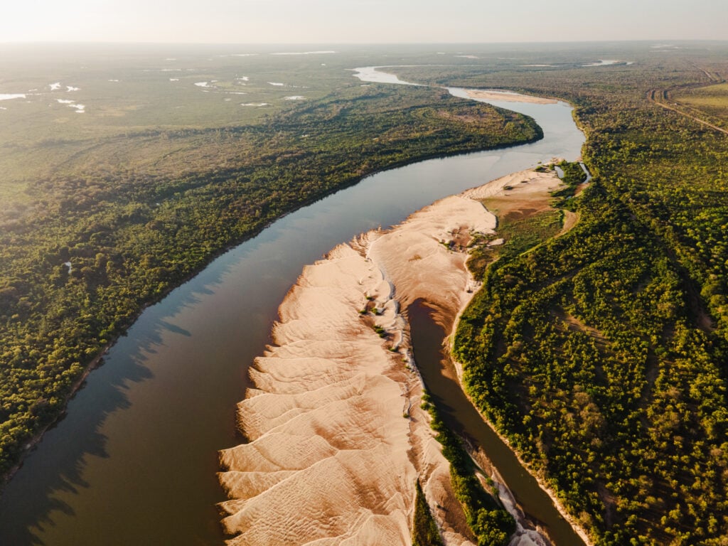 Vista aérea do Rio Araguaia em Goiás ao pôr do sol, com meandros e vegetação de Cerrado nas margens