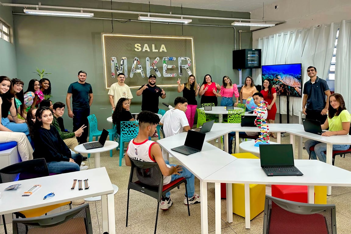 Sala de aula em escola técnica com estudantes usando laptops, ambiente moderno, em composição horizontal