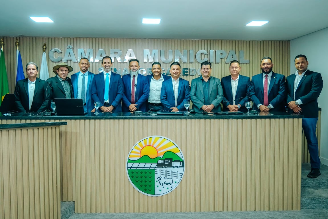 Plenário de câmara municipal, com tribuna, cadeiras e bandeiras; imagem ilustrativa de ambiente legislativo