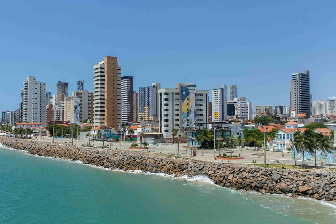 Skyline de Fortaleza visto da Praia de Iracema, prédios altos na orla ao pôr do sol