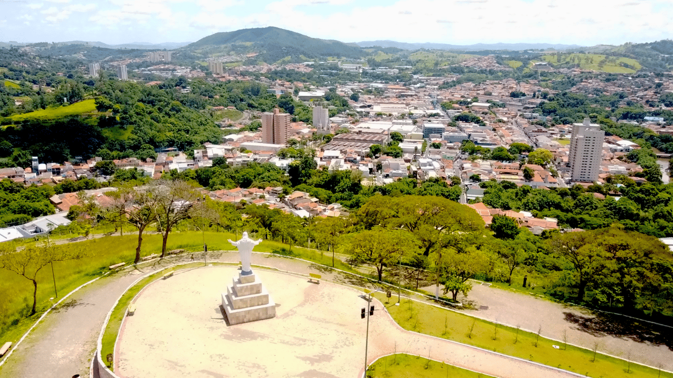Paisagem urbana do interior paulista, ao entardecer, com praça e áreas verdes ao fundo