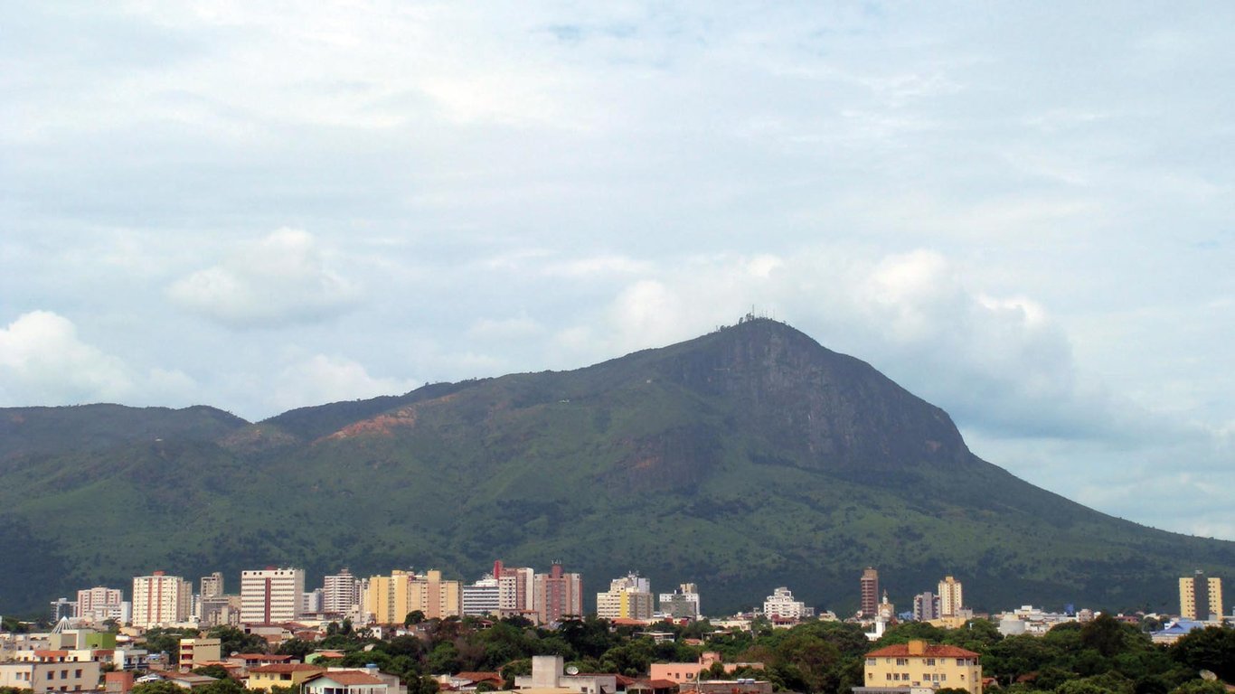 Skyline de Governador Valadares com o Pico da Ibituruna ao fundo, ao entardecer