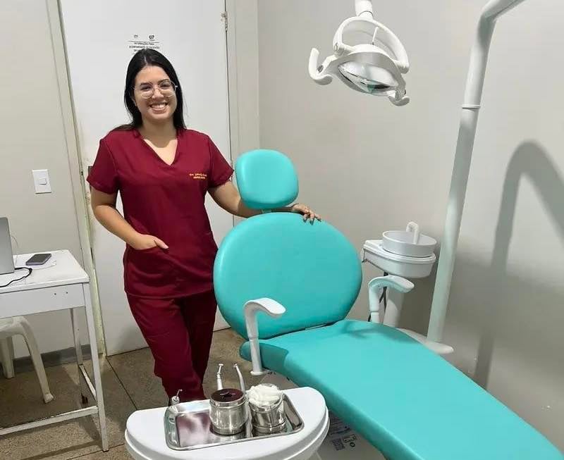 Ambiente de consultório odontológico público com equipe atendendo paciente.