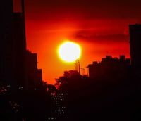 Skyline de Campinas ao entardecer, com edifícios e áreas verdes ao fundo