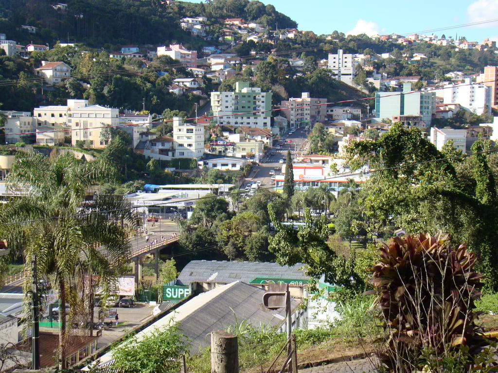 Vista aérea dos vinhedos e da área urbana de Videira, com morros verdes ao redor