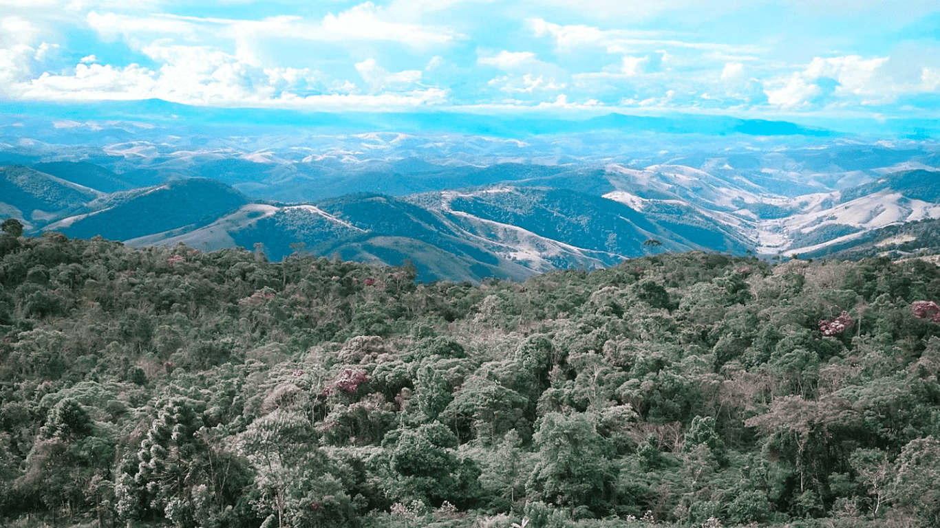 Vista aérea do Vale do Paraíba com morros verdes e vegetação densa