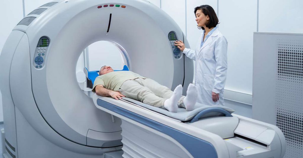 Tomógrafo em operação por técnica em radiologia, em ambiente hospitalar moderno