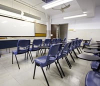 Sala de aula de escola pública com carteiras e quadro branco