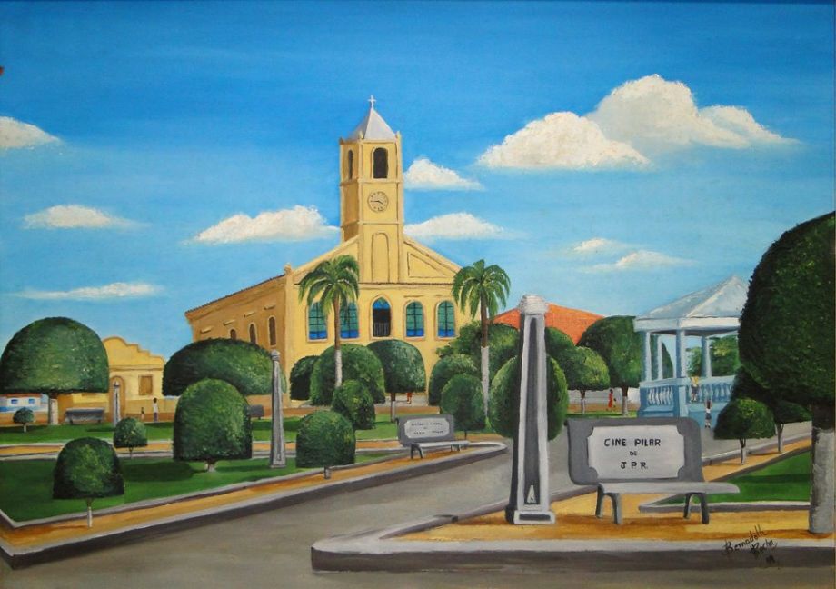 Cenário urbano de pequena cidade do interior paulista, com prédio histórico, árvores e céu azul