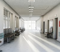 Corredor de hospital público no interior de São Paulo, iluminado e com cadeiras de espera.