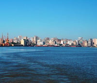 Vista panorâmica de Porto Alegre com o Lago Guaíba ao entardecer.