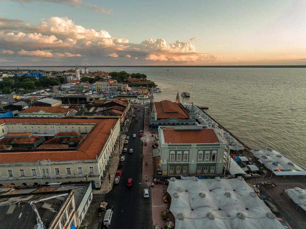 Vista aérea de Belém do Pará, com o complexo do Ver-o-Peso e a Baía do Guajará ao entardecer