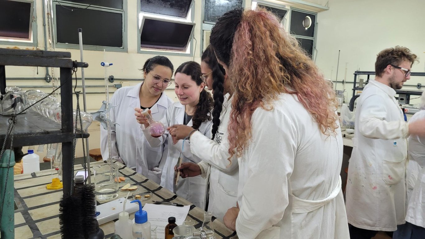 Professor em laboratório didático de ciências, com estudantes