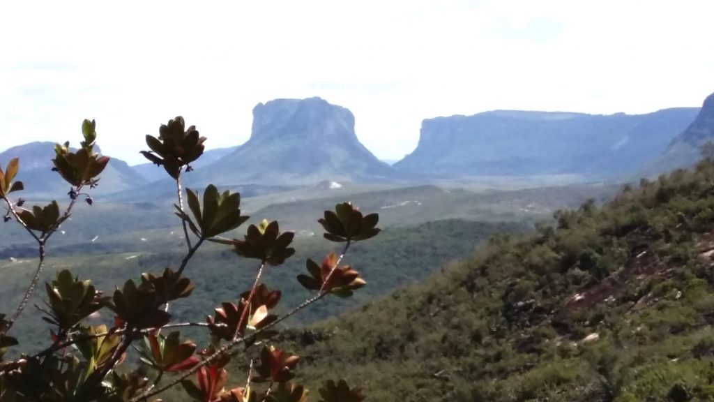 Paisagem do sertão baiano com estrada vicinal ao centro, vegetação de caatinga e morros ao fundo