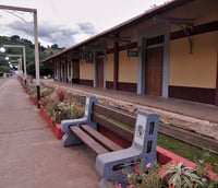 Paisagem urbana no centro de Paraguaçu MG em dia ensolarado com comércio ao fundo.