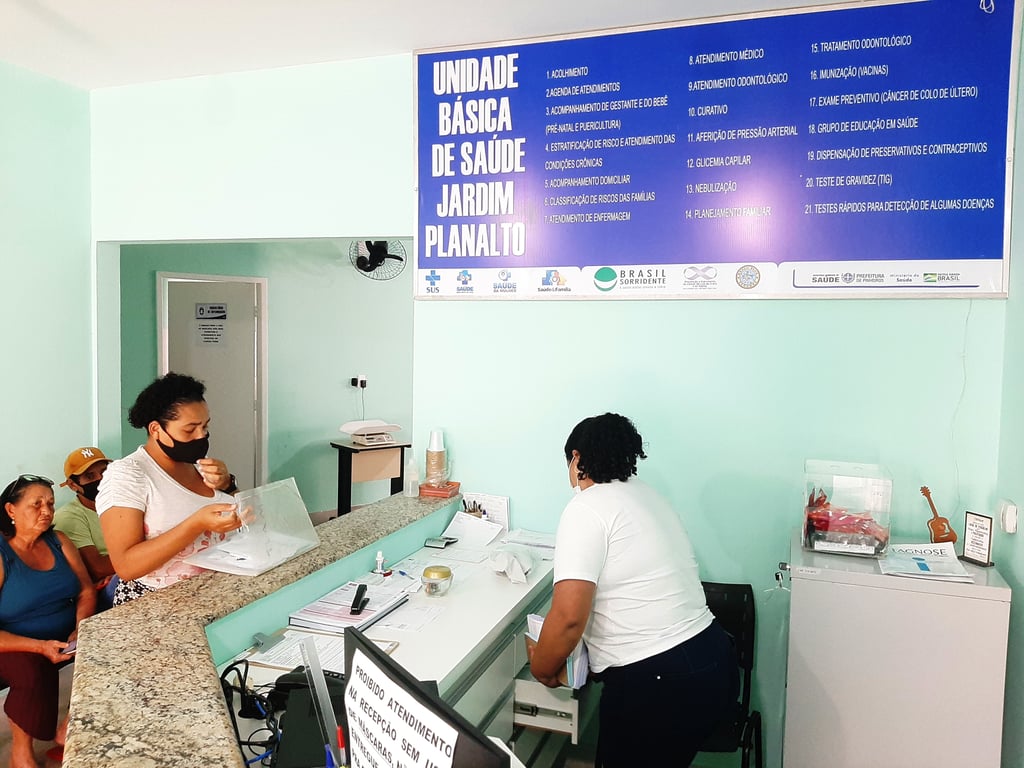 Atendimento em Unidade Básica de Saúde no Brasil, com profissionais auxiliando pacientes