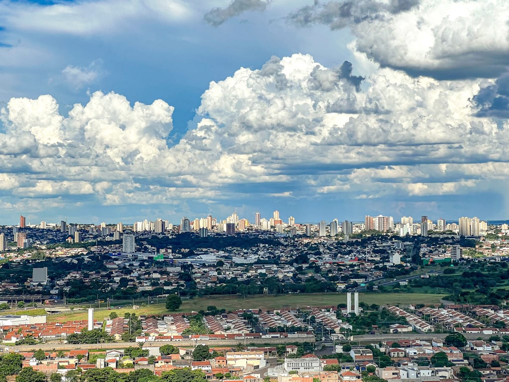 Vista aérea de Presidente Prudente (SP) ao entardecer, com prédios e nuvens no céu