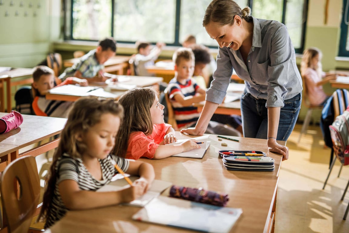 Professora interagindo com crianças em sala de aula inclusiva