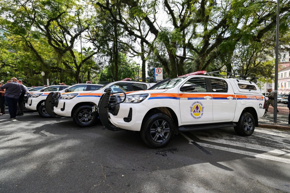 Viaturas da Defesa Civil em atividade, em área arborizada