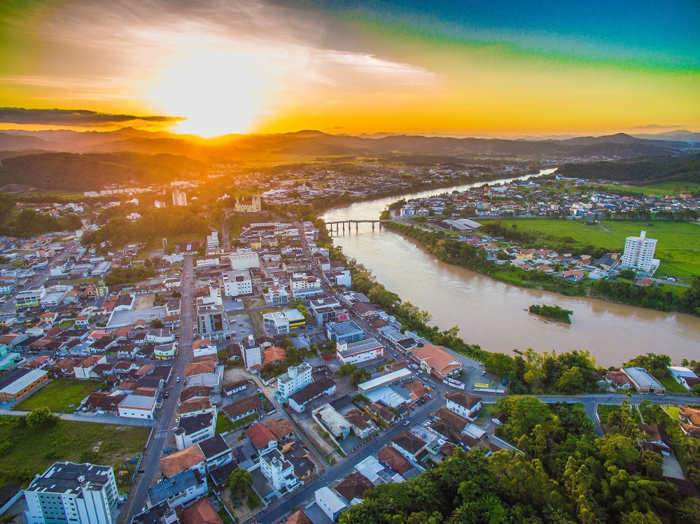 Vista aérea de Gaspar SC com o rio Itajaí-Açu ao pôr do sol.