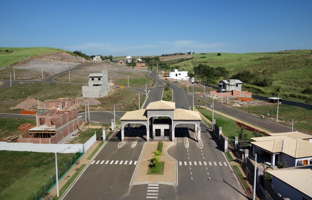 Vista aérea de cidade do interior paulista, com área urbana e vegetação sob céu ensolarado