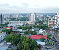 Vista aérea de Manaus ao entardecer, com o Rio Negro e a skyline urbana ao fundo